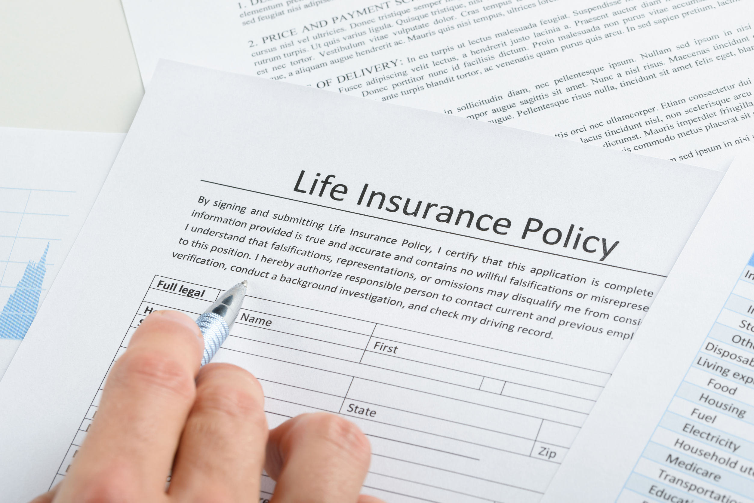 close-up of person hand filling life insurance policy application form